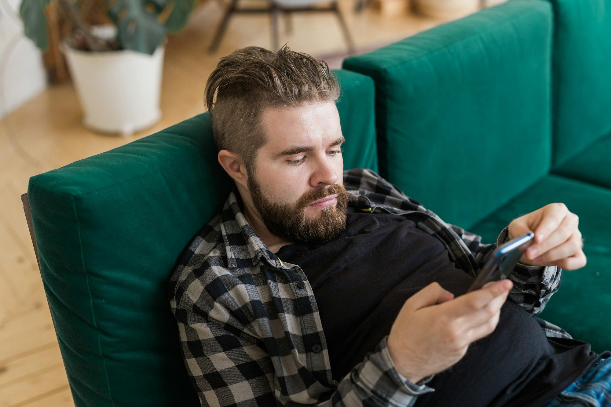 Young man surfing on social networking site using smartphone. Technologies and internet concept.